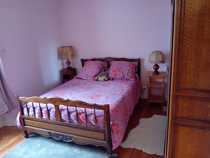 Une chambre du gîte, avec son lit double en bois et son armoire en chêne
